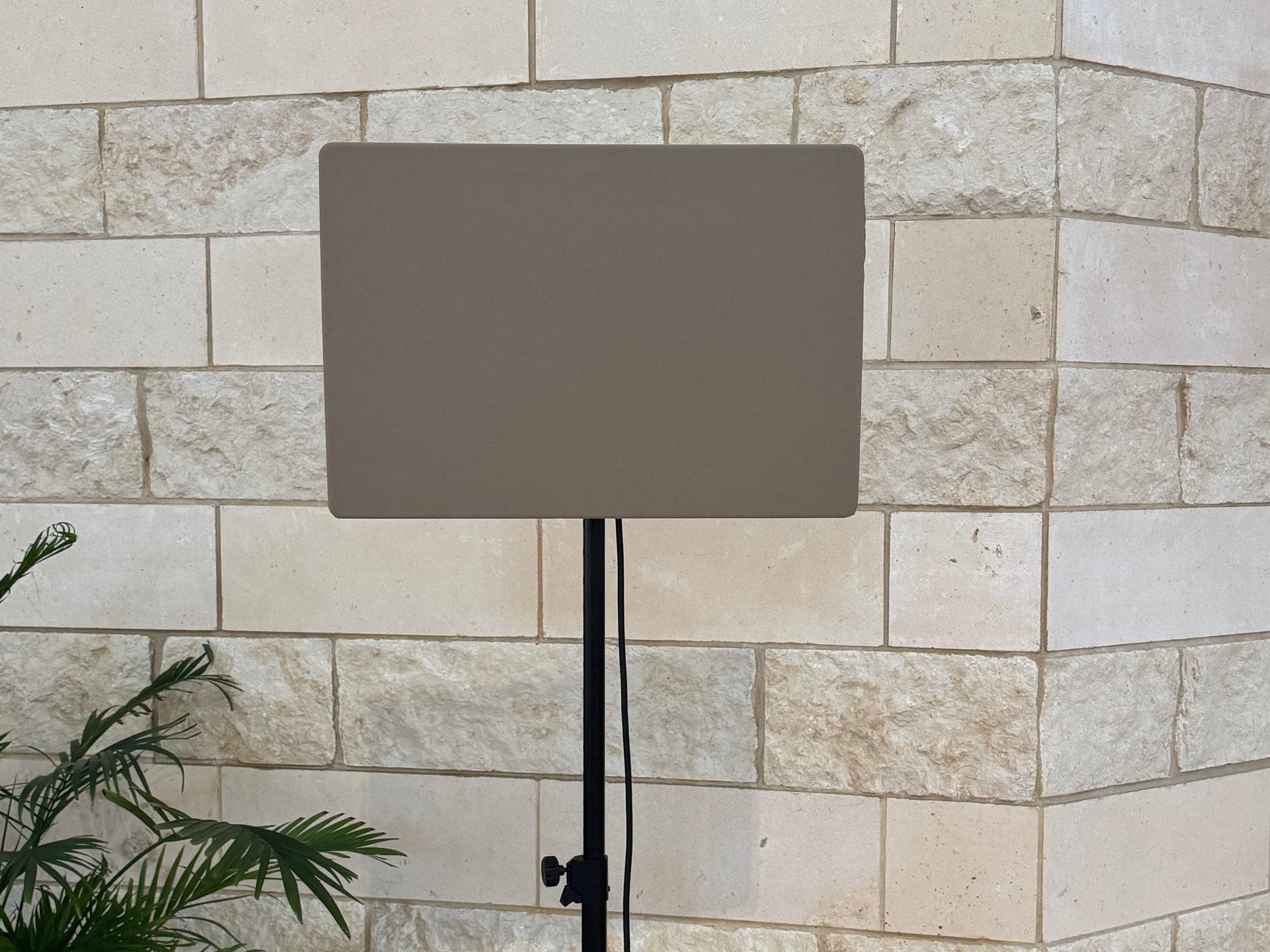 A single DML500 flat panel speaker on a stand in front of a limestone sanctuary wall