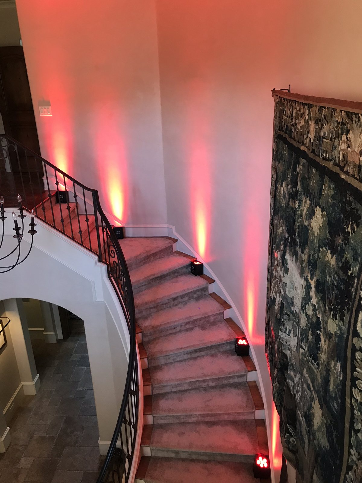 Amber uplighting throwing warm color up an exposed brick wall at a Dallas event venue