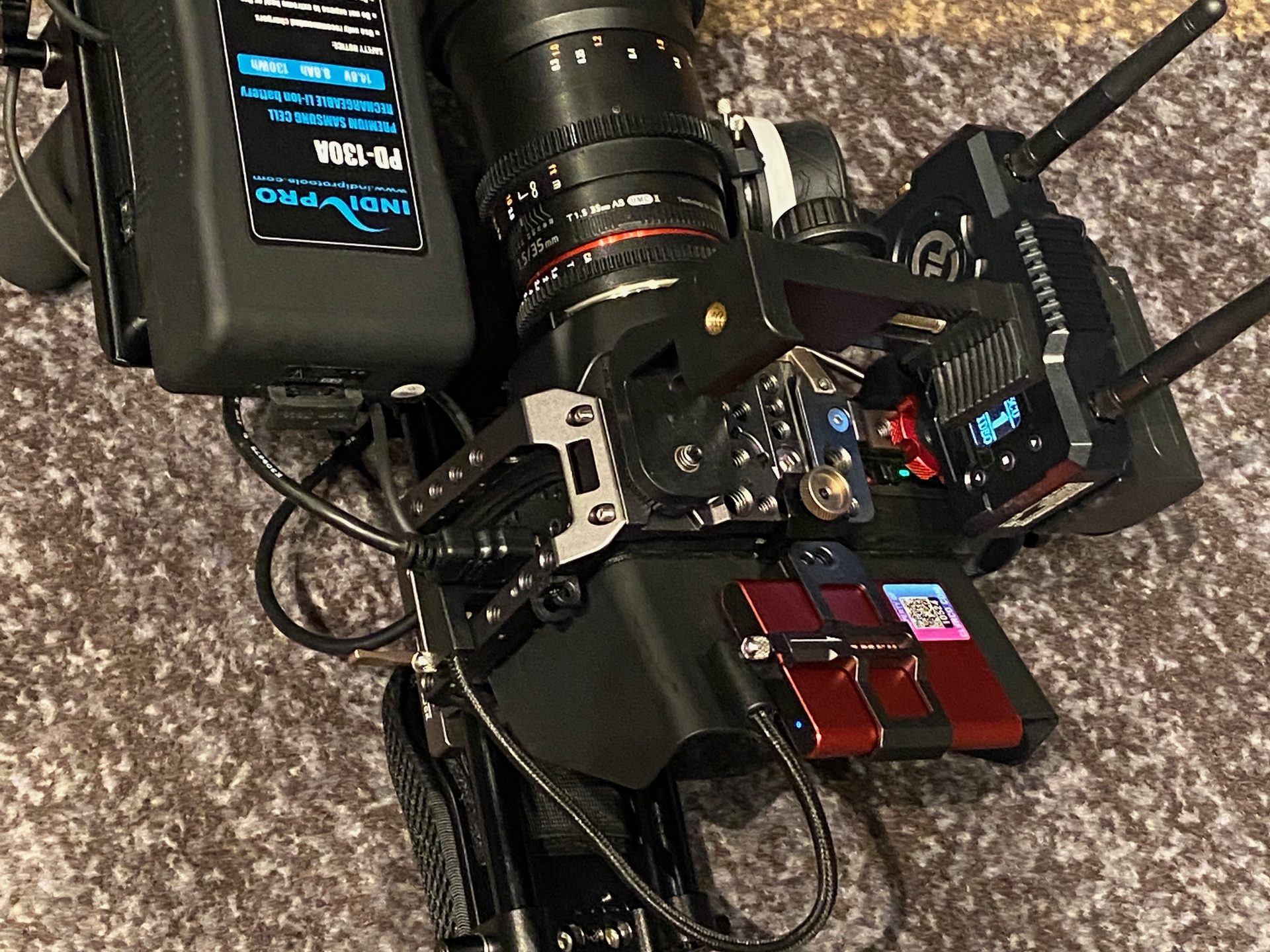 A cinema camera rig with a V-mount battery, a 35mm cine lens and a wireless video transmitter