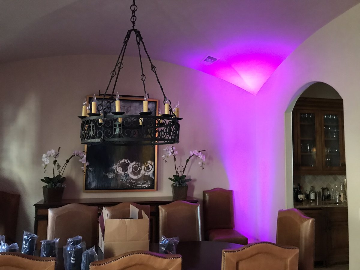 Magenta uplighting washing the walls around a ballroom dance floor at a Fort Worth wedding reception