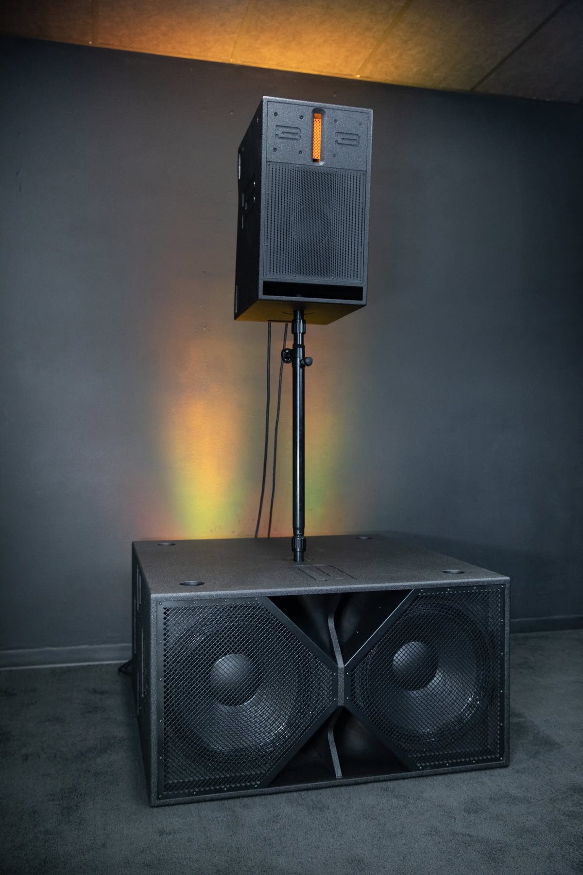 A powered speaker on a stand with a subwoofer below it, set up as part of a sound system rental in Dallas