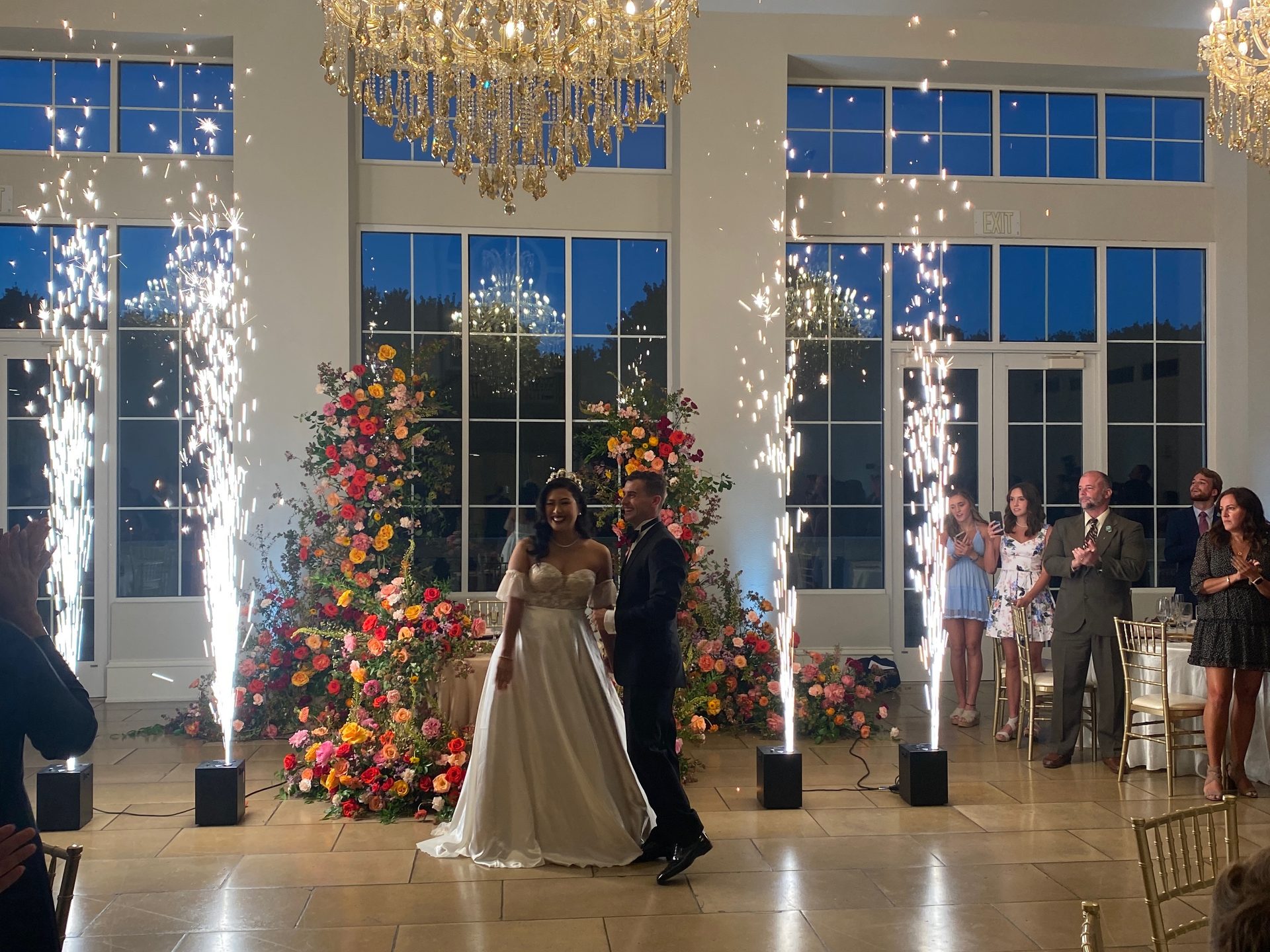Cold spark fountains firing behind a couple during their first dance at The Olana in Hickory Creek, Texas