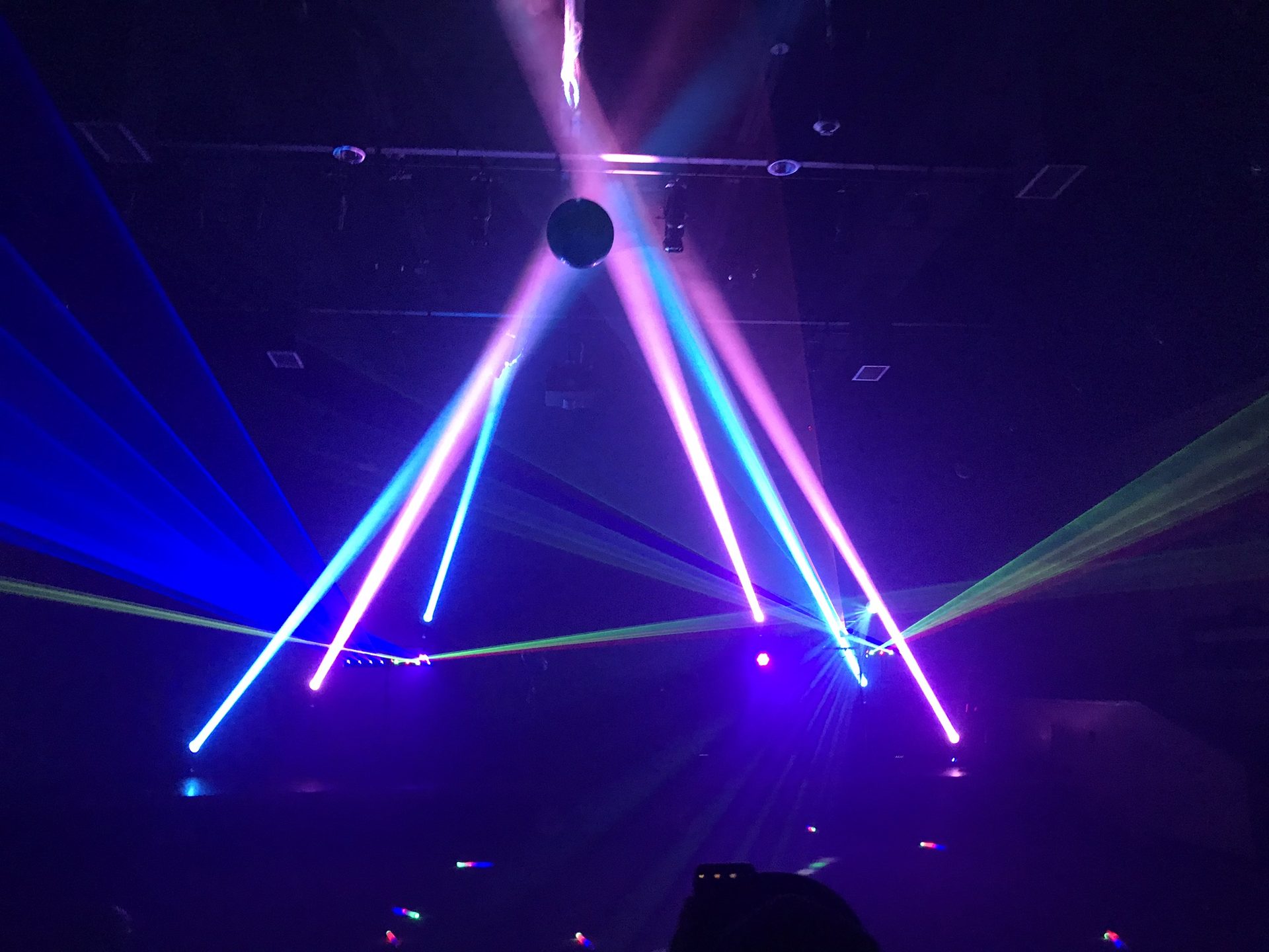 Haze giving shape to lighting beams over a dance floor at a Dallas event
