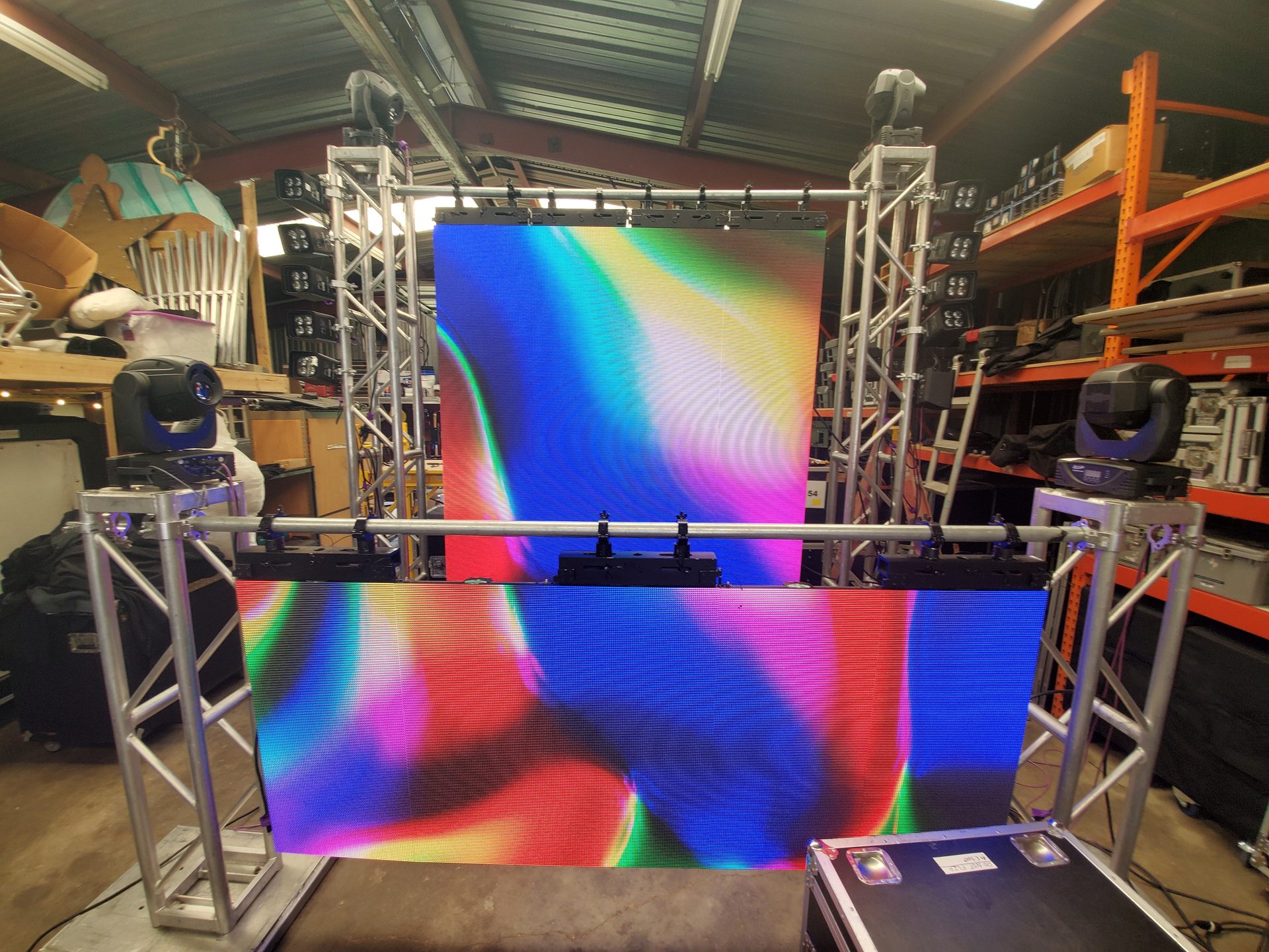Moving head fixtures on truss beside an LED wall, set up and tested in the Dallas Event Audio warehouse